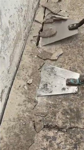 Removing damaged concrete floor layers using a flat metal scraper to create a clean smooth surface