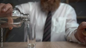 Close-up of a man pouring alcohol from a bottle into a glass. Alcohol addiction, alcoholism concept. drunk businessman.
