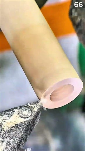 Using a woodturning chisel on a lathe to hollow and shape the end of a wooden cylinder for a smooth