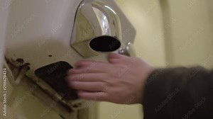 Using an electric hot air hand dryer in a public washroom