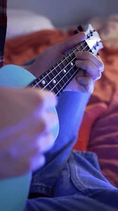 clip-3681072735-musician-sits-plays-repetitive-chord-progression-on