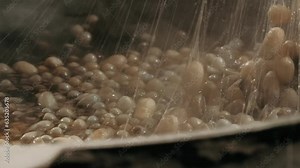 Traditional silk production. Processing Boiling silkworm cocoons in hot water. The process of producing silk by hand closeup from Cocoon to Silk thread