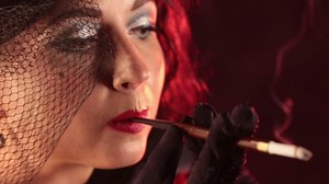 Burlesque Girl Smokes a Cigar in Glamorous Style