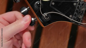 Putting new string on an electric guitar, string changing and tuning Stock Video
