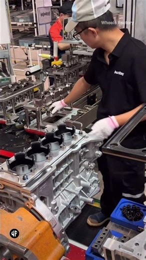 Workers assembling pistons for internal combustion engines at the Geely Automobile factory