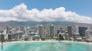 Panorama view on modern ocean front hotel buildings. Hi-rise luxury resorts with beautiful teal blue ocean views. Waikiki beach on green mountains background. Inspiring dream trip at Hawaiian resorts