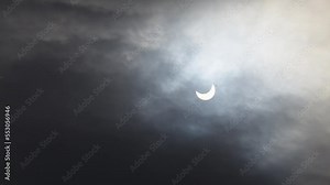 A solar eclipse in cloudy weather through a cloud. partial solar eclipse.
