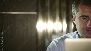 A middle aged man working at a computer in the lab.
