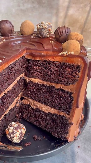 Chocolate Truffle Cake has rich, moist chocolate cake layers frosted in milk chocolate buttercream & topped with homemade chocolate truffles 🥳 #chocolatecake #chocolatetruffles #fypage #layercake #chocolatecakerecipe #onebowlcake #dripcake #fypppppppppppp #truffles #homemadetruffles