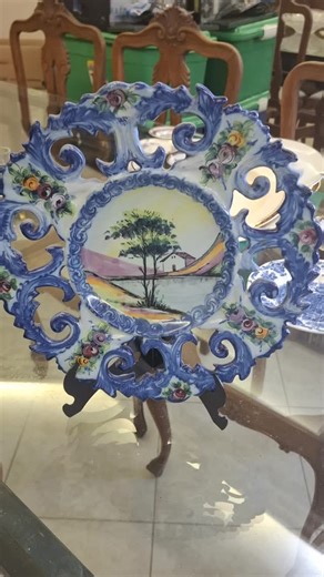 Olívia Antiguidades on Instagram: "Prato Decorativo Português Antigo – Pintado à Mão | Década de 1950 Excepcional prato decorativo português antigo, datado aproximadamente da década de 1950, com inscrição original no verso: Made in Portugal – Hand Painted – Vestal. Peça ricamente trabalhada, com borda vazada em relevo, pintura manual em azul e policromia floral, além de paisagem central pintada à mão, revelando o refinamento da cerâmica artística portuguesa do pós-guerra. Um objeto de forte pres