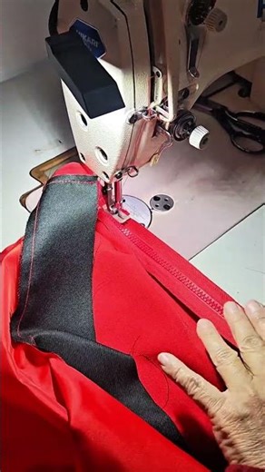 sewing a red fabric using a professional machine to join the material for a neat garment assembly