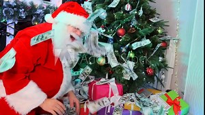 Side view, cheerful Santa Claus throws money around, many cash bills next to Xmas tree decorated with twinkling garlands with gifts boxes under it, close up. Christmas party time holiday. Stock Video