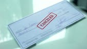 Cheque document canceled, hand stamps seal on official paper,...