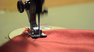 Download Sewing machine knitting a red fabric for free
