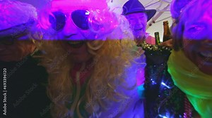 group of older friends senior pensioners dressed extravagantly celebrating and hugging together - birthday party, new year, carnival, fun for seniors concept