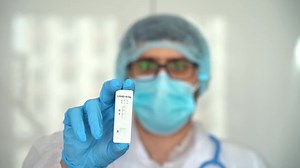 Male doctor holds rapid antigen test for covid-19 in laboratory. Quick swab method to test Coronavirus SARS-CoV-2. PCR