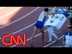 A runner celebrates by shoving 14 year old mascot