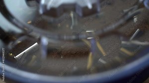 Bullet brass cases viewed through lid of tumbling machine while being cleaned for reloading