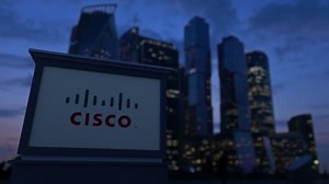 Street signage board with Cisco Systems logo in the evening. Blurred business district skyscrapers background. Editorial 4K clip