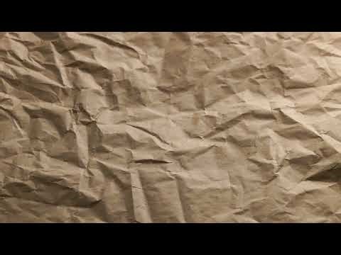 looped spinning close-up full-frame background of crumpled brown craft paper
