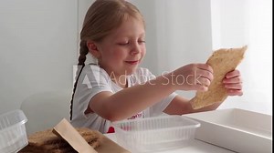 A child sows microgreen peas on a linen mat in a clear plastic container. Sowing and growing microgreens. Children's education in gardening