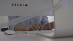 Young Professional Typing at Keyboard