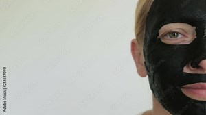 Woman close-up in half face with black cosmetic mask