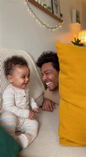Dad plays a simple prank on baby by hiding behind a couch cushion, then popping out to say "peek-...