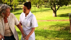 Nurse talking to woman using walker outside | Free Stock Video Footage