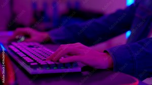 RGB neon light. finger tapping on neon backlit gaming keyboard, cybersport. Professional esport gamers. Gamer playing a video game with keyboard. Computer hands typing on keyboard browsing online.