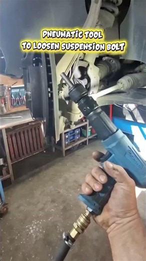 Uses Pneumatic Tool To Loosen Suspension Bolt