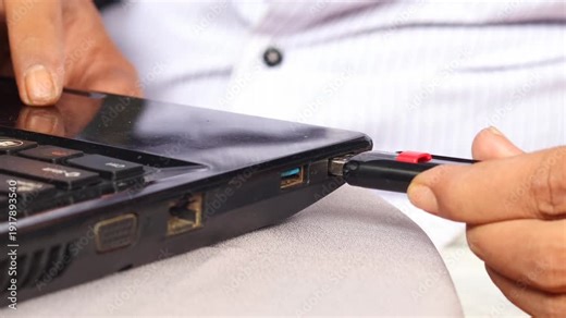Man plugging a USB flash drive into laptop computer. Concept of data transfer, file backup, cybersecurity, and digital technology.