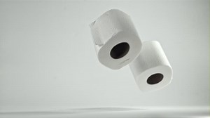 Toilet paper falling on the table on a white background. Filmed on a high-speed camera at 1000 fps. High quality FullHD footage