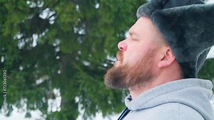 A man with a beard and a winter hat takes a deep breath of cool, clean winter air. Close-up of human breathing. Stock Video