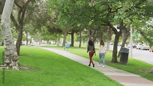 Two women walking together at the park