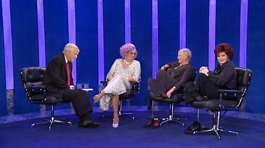 Relive one of the most iconic moments in television history as Michael Parkinson interviews Dame Edna Everage, the unforgettable comedic creation of the late Barry Humphries. Joined by Dame Judi Dench and Sharon Osbourne, Dame Edna steals the show with her sharp wit, outrageous humor, and unexpected accusations that leave Parkinson in stitches. This 16-minute segment is non-stop laughter, showcasing why Dame Edna was a genius in both character and comedy. A must-watch for fans of classic talk sh