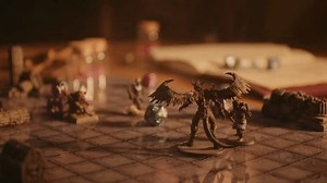 A person plays a fantasy roleplaying game, moving miniatures and rolling dice
