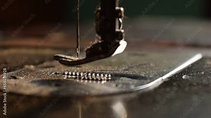 Close up an antique sewing machine and needle working without threads on table wood