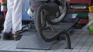 Motorcycle service officers check the engine and exhaust gases using a special tool mounted on the muffler