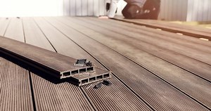 clip-1052669660-wpc-terrace-construction---worker-installing-wood