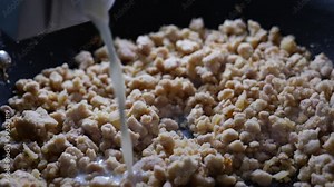 Preparation of traditional bechamel for homemade meat croquettes: milk, onion, minced Iberian pork and nutmeg. 4K high definition, smooth movements.