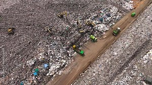 Aerial top view of A Huge Waste, garbage, dump, rubbish landfill. A landfill compactor, group of workers sort out the garbage in the landfill. Trash trucks dump waste polluting products.
