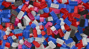 Pile of colorful children building brick blocks moving around in a container. Interesting abstract plastic toy animation background for animation and video or movie projects.