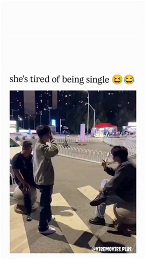 vibemovies.plus on Instagram: "The Instagram reel shares a viral video from early October 2025 depicting a woman in a white dress boldly giving a man a piggyback ride across a busy nighttime crosswalk in China, captioned "she's tired of being single " to emphasise her playful initiative in romance. With 81,000 views and 464 likes shortly after posting, it sparked humorous replies joking about skipping dating stages and "claiming" partners, reflecting its appeal as light-hearted relationship cont