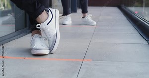 Social distancing, feet and people standing in a queue outdoor of a medicare clinic for a covid test. Healthcare, safety and closeup of feet with shoes in a line or row outside a medical center.