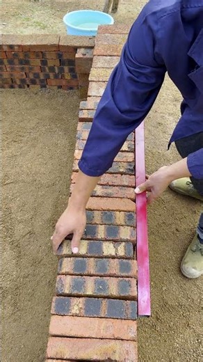 Using a red tool to level brick walls for a smoother finish!