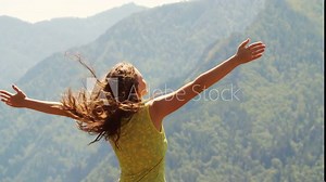 Beautiful woman standing on top of mountain and stretching out hands Stock Video