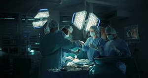 Male and Female Surgical Team Working on a Critical Operation in a Dark Room, Each Hospital Member Focusing on Their Role to Keep the Procedure Moving Forward and Patient Alive and Healthy