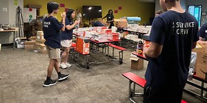 Hundreds of young men gather with their moms to help school for homeless children