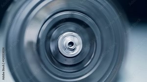 Close up of a spinning industrial machine part, showcasing the concept of speed, motion, and manufacturing. The blurred motion creates a sense of dynamism and power